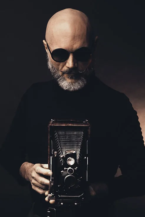 Portrait of a man holding a vintage camera