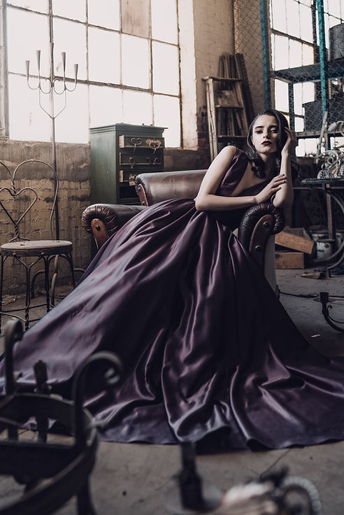 Woman in purple gown, fashion portrait, industrial setting