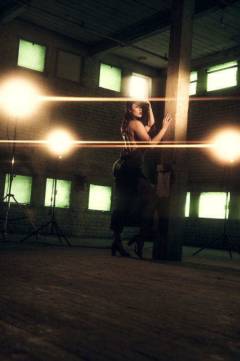Woman in dark dress, fashion portrait, industrial setting